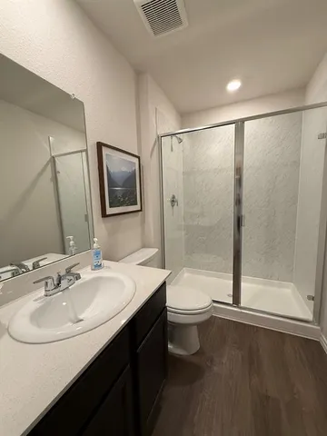 a bathroom with a sink a toilet and shower