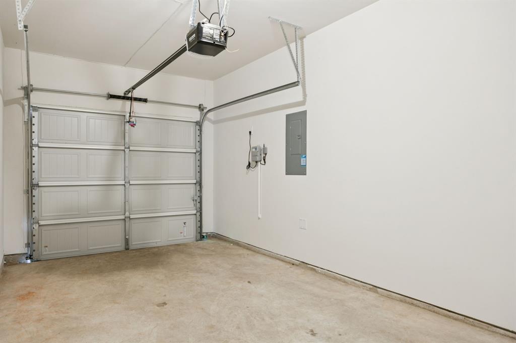 323 Clematis Street Princeton, TX 75407 - Photo 31 of 34 Garage with electric panel and a garage door opener