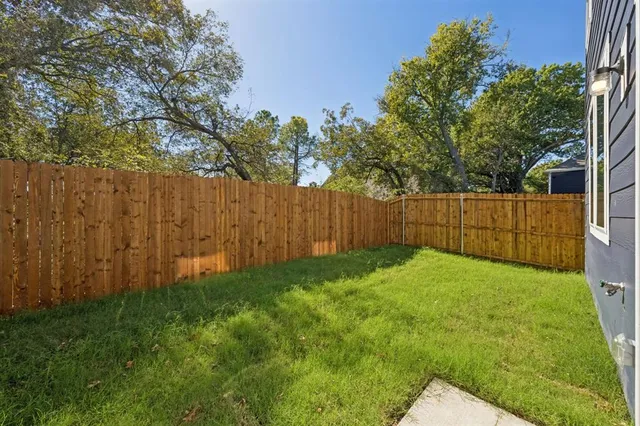 a view of backyard with wooden fence