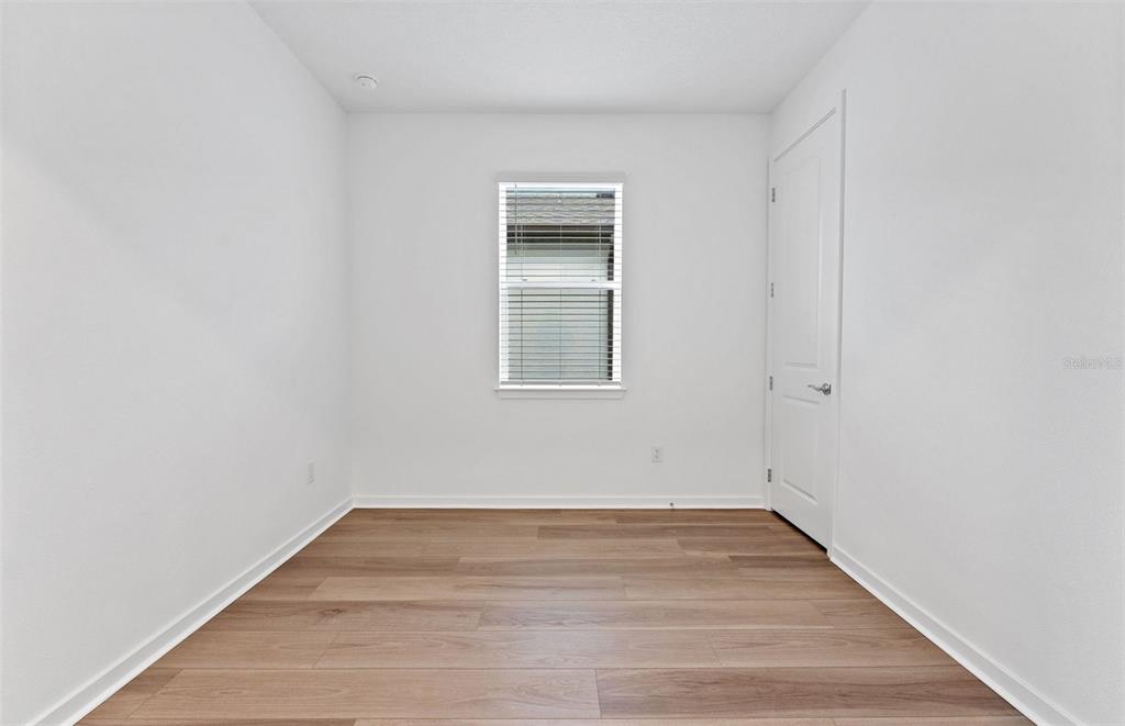 13748 Rocky Pne Place Spring Hill, FL 34610 - Photo 14 of 30 a view of an empty room with wooden floor and a window