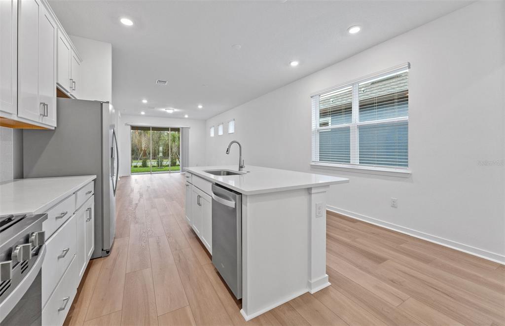 13748 Rocky Pne Place Spring Hill, FL 34610 - Photo 4 of 30 a kitchen with granite countertop a sink stove and wooden floor