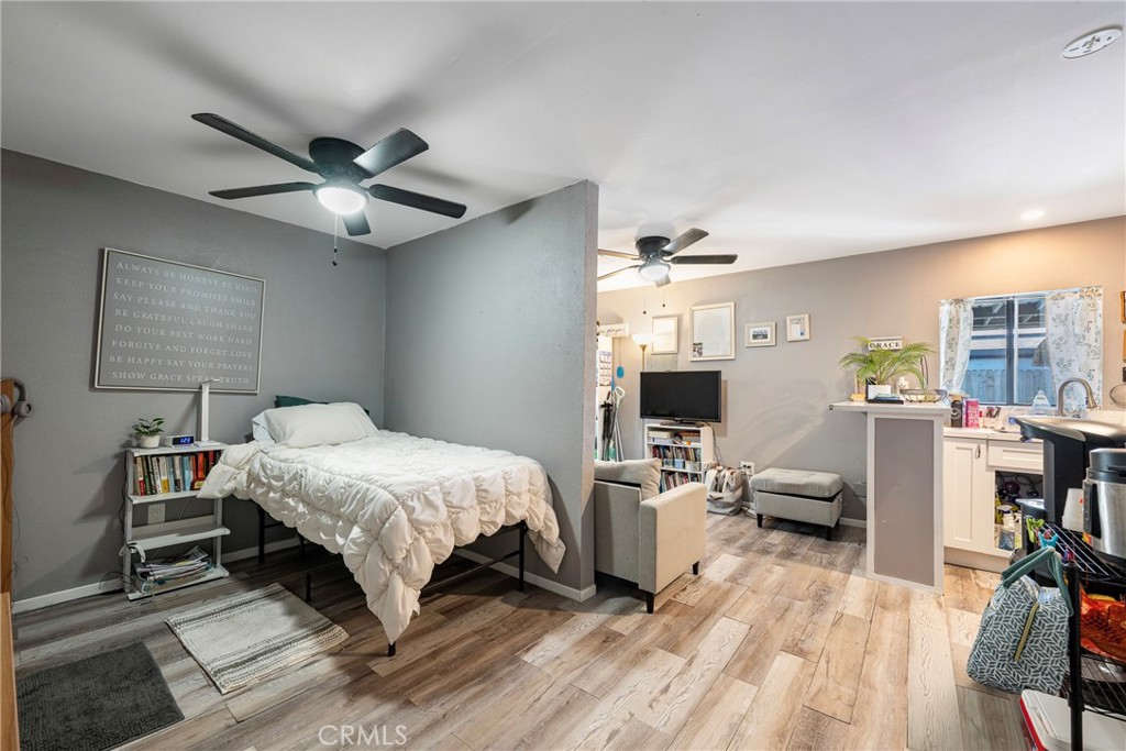11309 Telechron Avenue, Unit B Whittier, CA 90605 - Photo 13 of 17 a bedroom with a bed wooden floor and ceiling fan