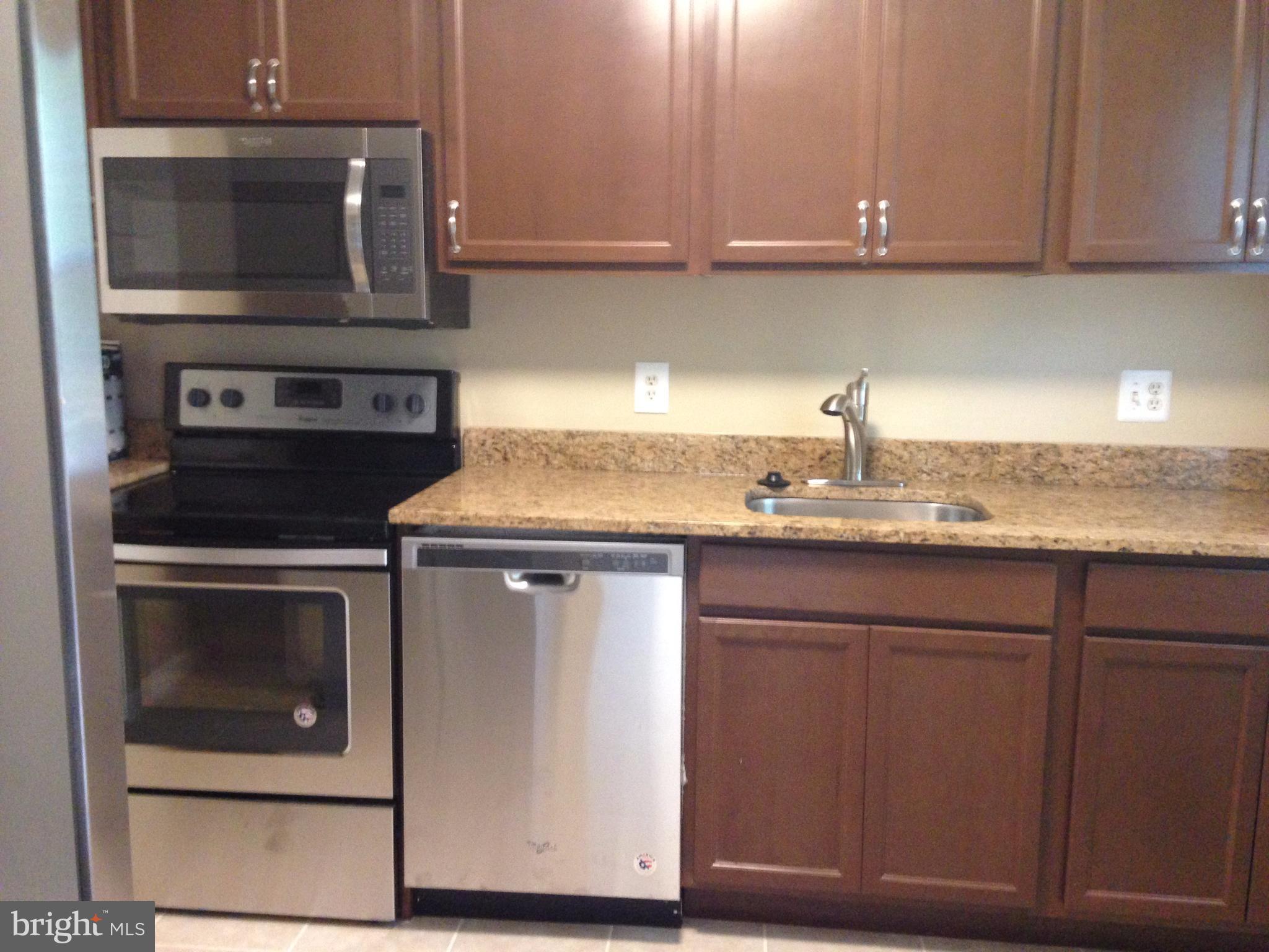 9072 Silver Maple Court Manassas, VA 20110 - Photo 3 of 14 a kitchen with granite countertop cabinets stainless steel appliances and wooden cabinets
