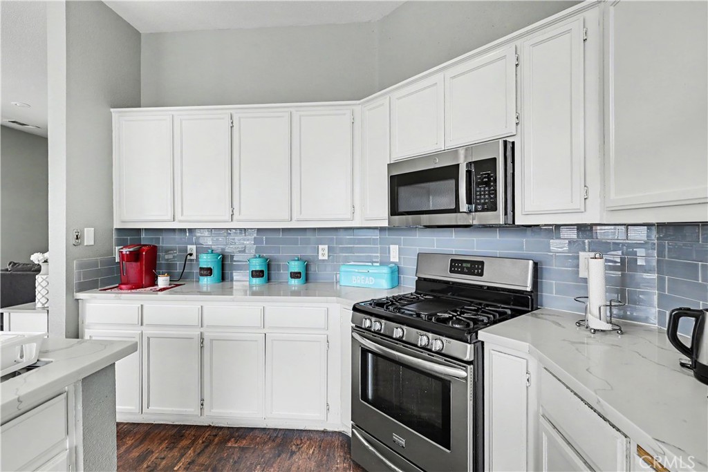 3632 Swan Court Merced, CA 95340 - Photo 25 of 50 a kitchen with granite countertop white cabinets and white appliances