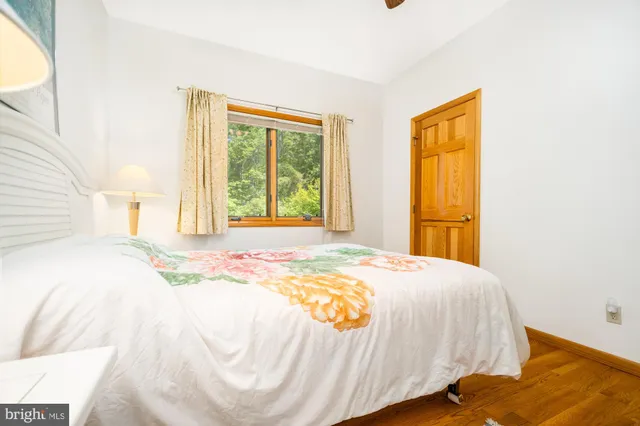 a bedroom with a bed and dresser with mirror