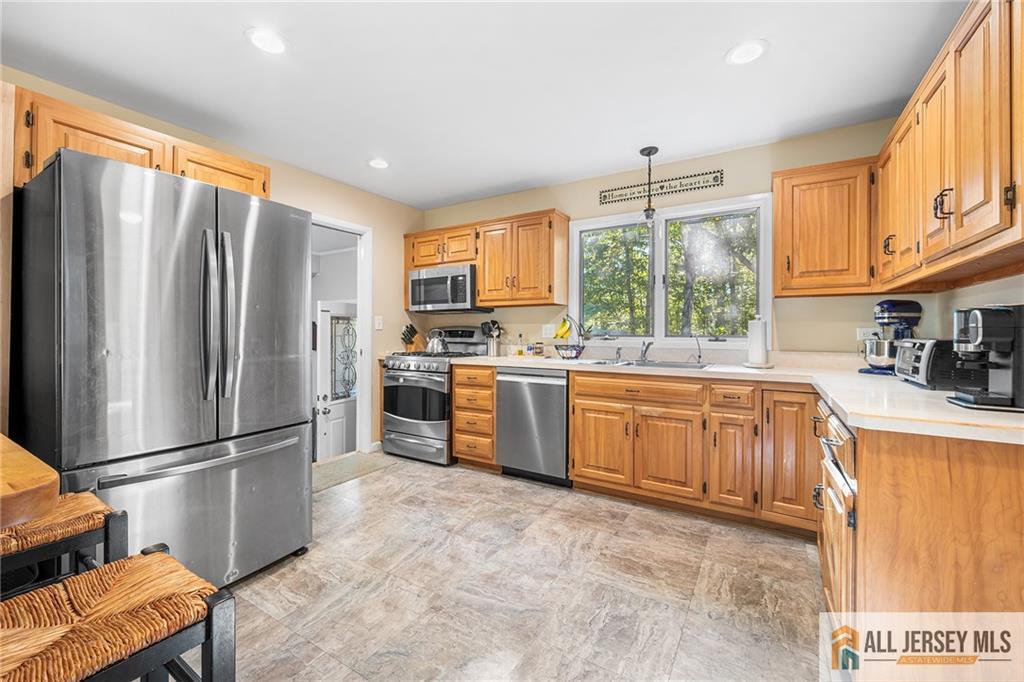 1266 Mt Vernon Road Bridgewater, NJ 08807 - Photo 12 of 44 a kitchen with stainless steel appliances granite countertop a refrigerator a sink dishwasher a stove a washer dryer and a dining table with wooden cabinet