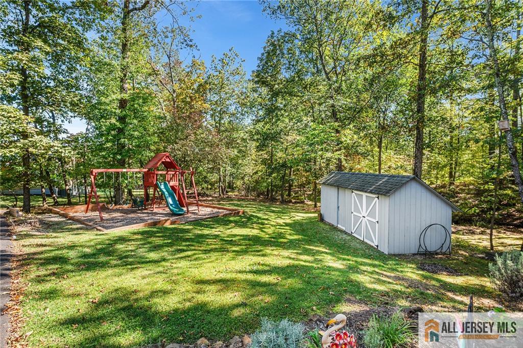 1266 Mt Vernon Road Bridgewater, NJ 08807 - Photo 40 of 44 a view of a backyard with a slide and a tree