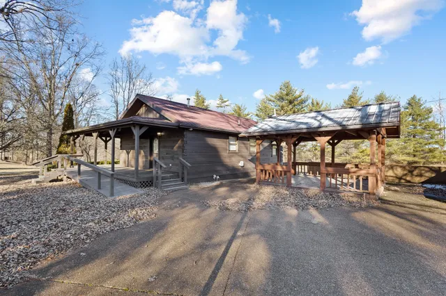 a view of a large room with large trees and wooden fence