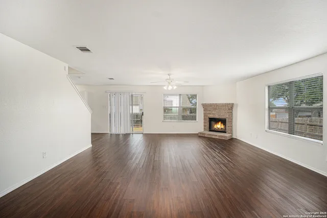 an empty room with wooden floor and fireplace