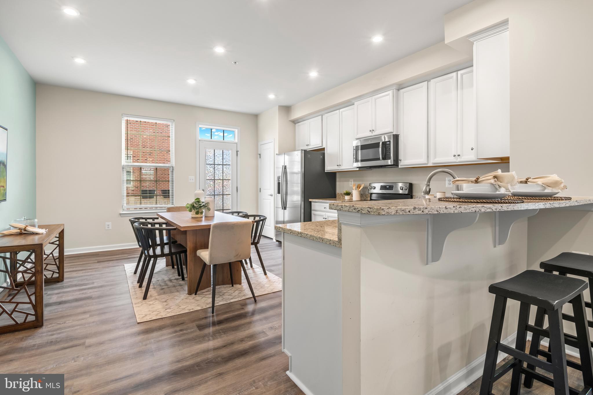 4701 Marlene Mews Baltimore, MD 21224 - Photo 5 of 39 a kitchen with stainless steel appliances granite countertop a table chairs sink refrigerator and cabinets
