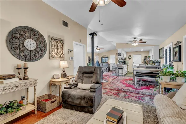 a living room with furniture a clock on wall and a flat screen tv