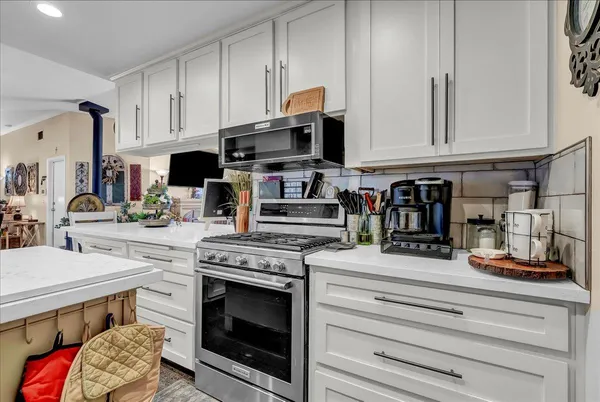 a kitchen with stainless steel appliances kitchen island granite countertop a refrigerator stove and sink