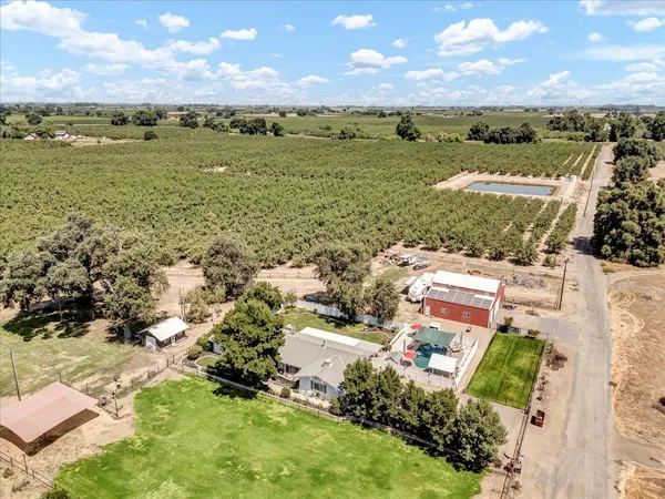 an aerial view of a house with a garden and lake view