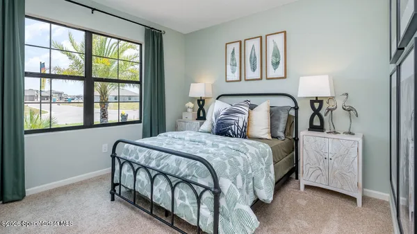a bedroom with a bed and a large window
