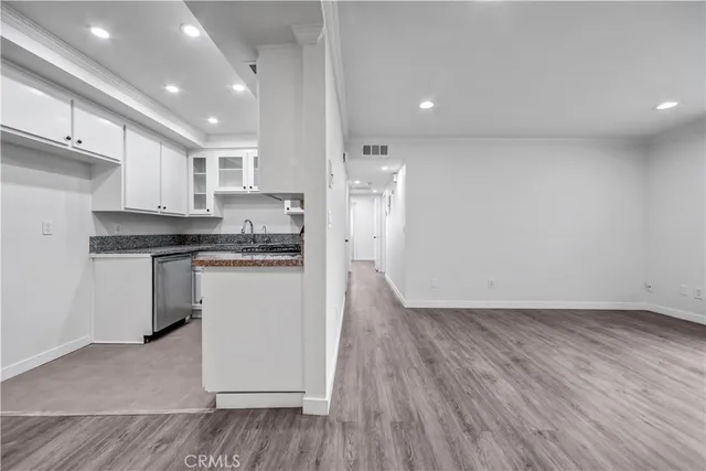 a kitchen with a refrigerator and white cabinets