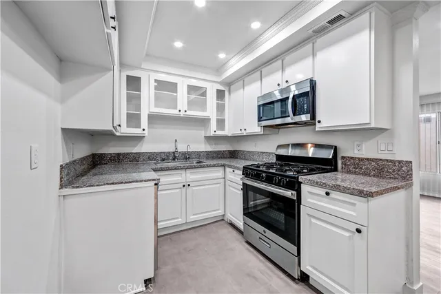 a kitchen with stainless steel appliances granite countertop a stove sink microwave and cabinets