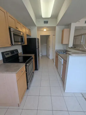 a kitchen with a sink a refrigerator and window