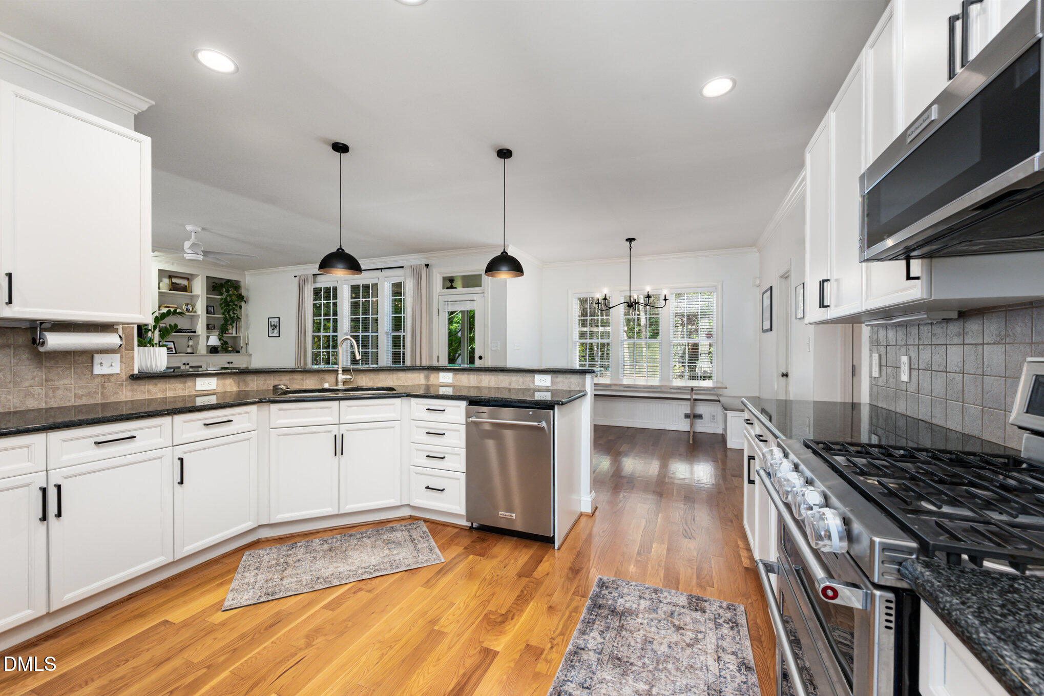 1613 Strategy Way Wake Forest, NC 27587 - Photo 11 of 40 a kitchen with stainless steel appliances granite countertop a stove and a wooden floors
