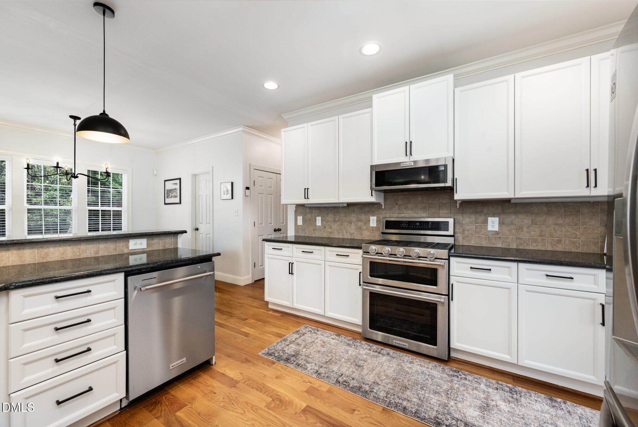1613 Strategy Way Wake Forest, NC 27587 - Photo 12 of 40 a kitchen with stainless steel appliances granite countertop a stove a sink and a microwave