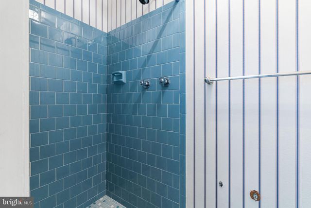 a bathroom with a granite countertop sink a mirror and a shower