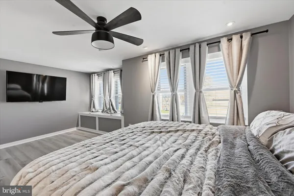 a bedroom with a large bed and a flat tv screen