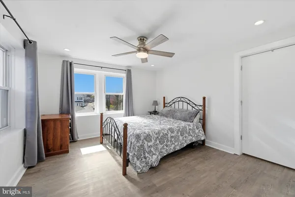 a bedroom with a bed ceiling fan and a window