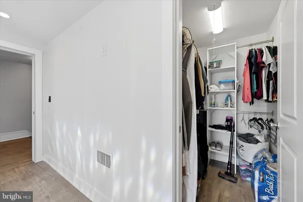 a view of walk in closet with clothes and shoes