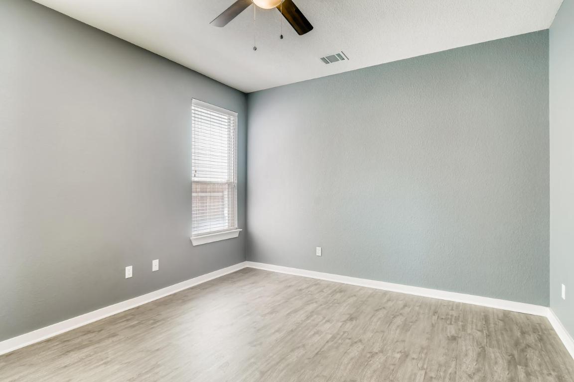 16229 Travesia Way Austin, TX 78728 - Photo 13 of 28 an empty room with a window and ceiling fan
