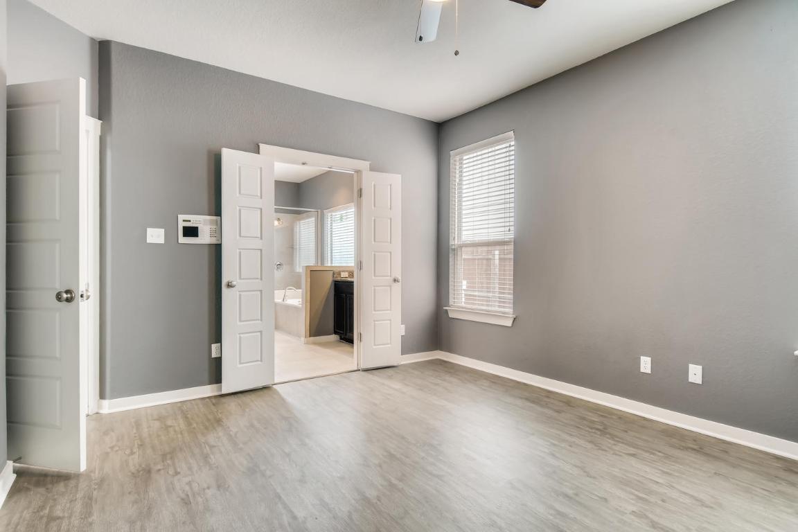 16229 Travesia Way Austin, TX 78728 - Photo 15 of 28 an empty room with wooden floor and windows