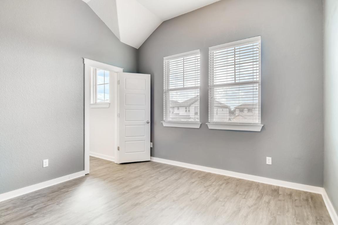 16229 Travesia Way Austin, TX 78728 - Photo 19 of 28 an empty room with wooden floor and windows