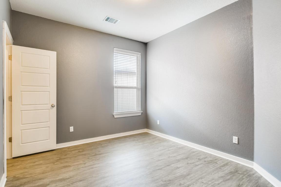 16229 Travesia Way Austin, TX 78728 - Photo 20 of 28 an empty room with wooden floor and windows