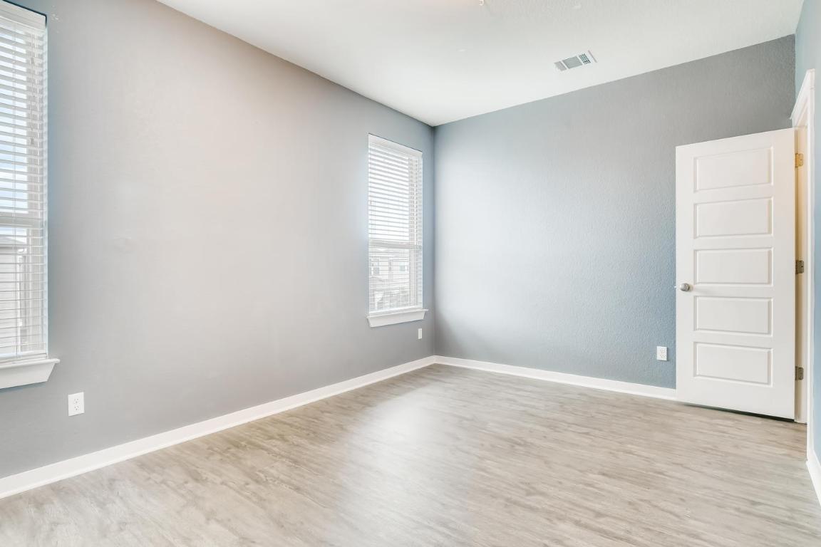 16229 Travesia Way Austin, TX 78728 - Photo 22 of 28 an empty room with wooden floor and windows