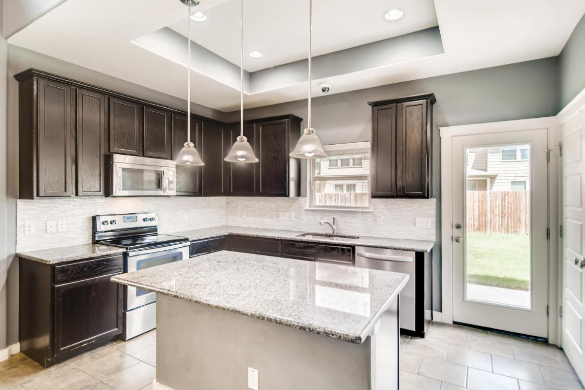 16229 Travesia Way Austin, TX 78728 - Photo 8 of 28 a kitchen with stainless steel appliances granite countertop a sink and a stove