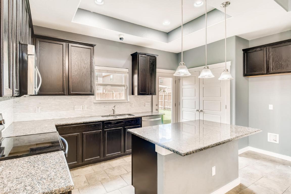 16229 Travesia Way Austin, TX 78728 - Photo 10 of 28 a kitchen with a sink counter top space and stainless steel appliances