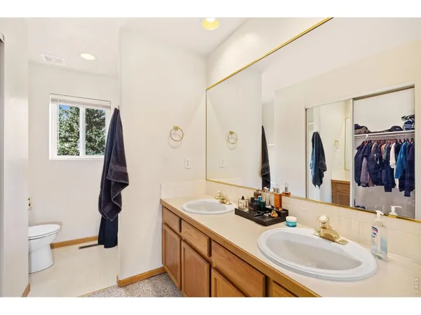 a bathroom with a double vanity sink toilet and a mirror