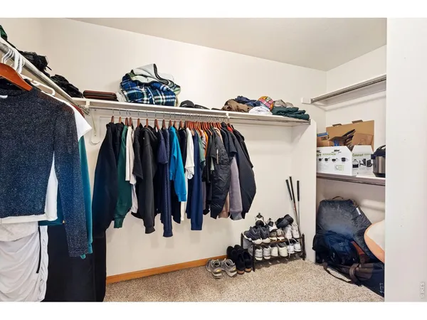 a view of walk in closet with clothes and shoes