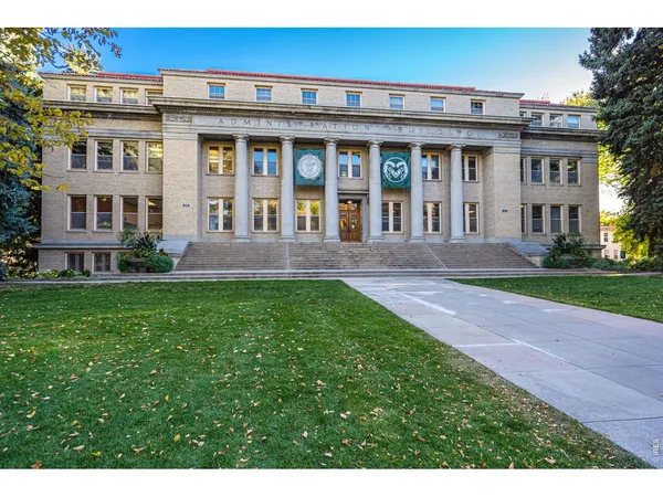 a front view of a house with a yard and potted plants