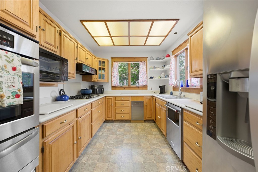 4456 12th Street Riverside, CA 92501 - Photo 16 of 70 a large kitchen with stainless steel appliances granite countertop a large window and a refrigerator