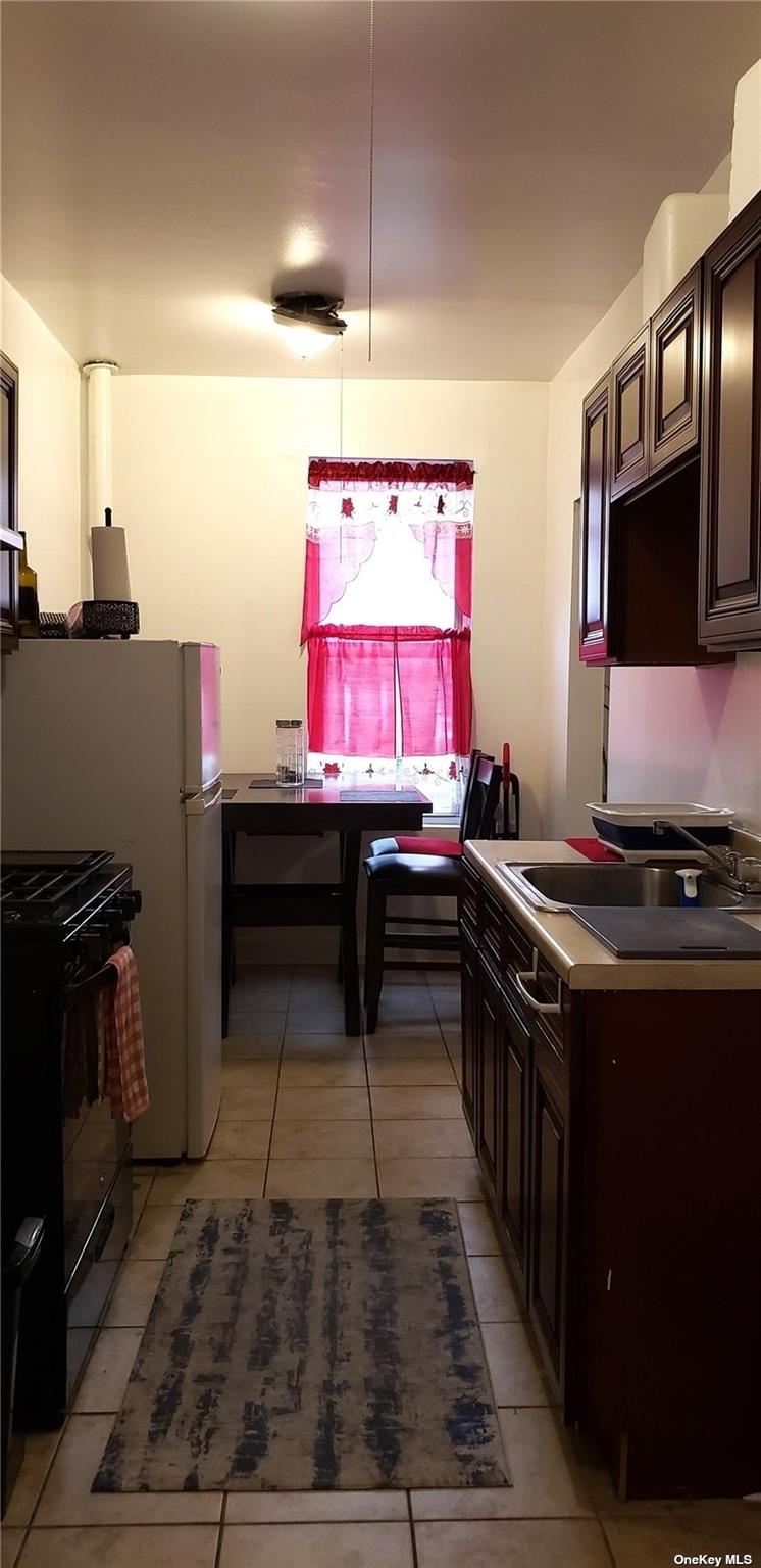 44-15 43rd Avenue, Unit 5N Queens, NY 11104 - Photo 9 of 11 a kitchen with granite countertop a stove and a sink