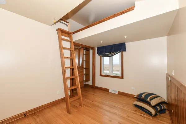 a view of a room with wooden floor and white walls
