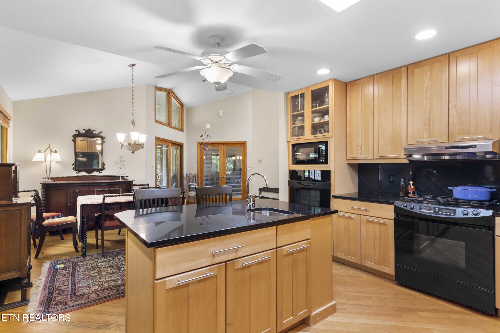 780 Old Emory Road Clinton, TN 37716 - Photo 19 of 33 a kitchen with stainless steel appliances granite countertop a stove top oven a sink a dining table and chairs with wooden floor