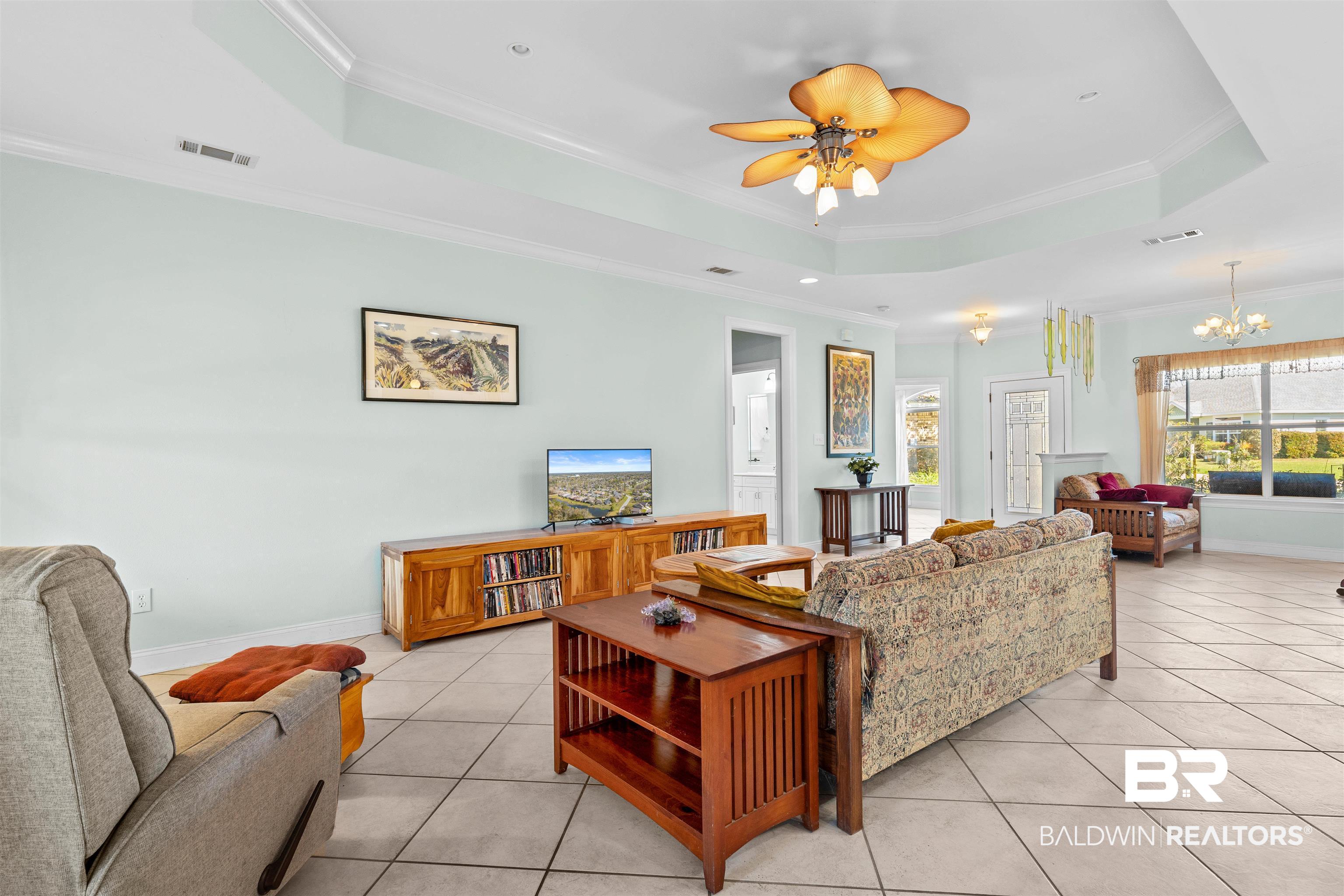 237 Hemingway Loop Foley, AL 36535 - Photo 9 of 49 Living room with a tray ceiling, light tile patterned floors, and visible vents