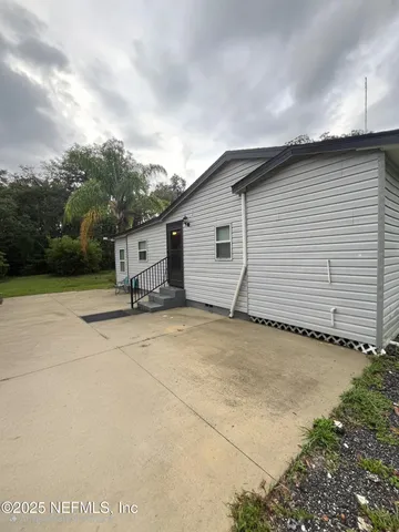 a view of a house with backyard and trees