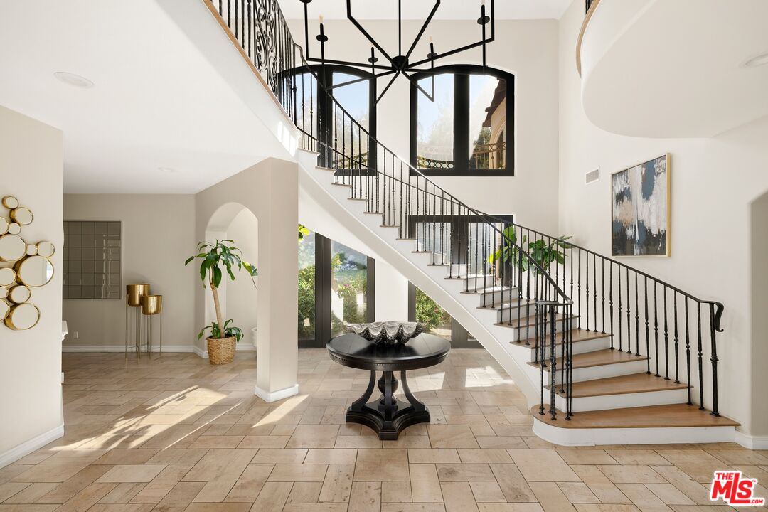 a view of staircase with lots of frames and flower vase