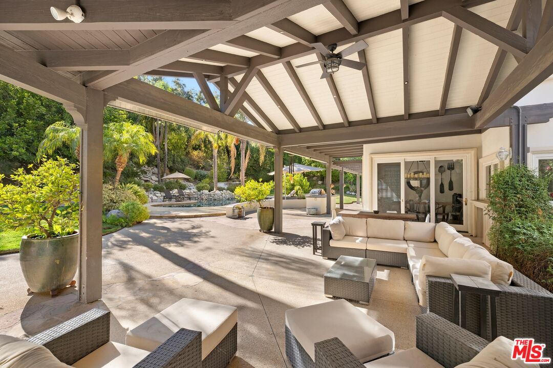 25217 Eldorado Meadow Road Hidden Hills, CA 91302 - Photo 15 of 28 a view of a patio with table and chairs potted plants with wooden floor and floor to ceiling window