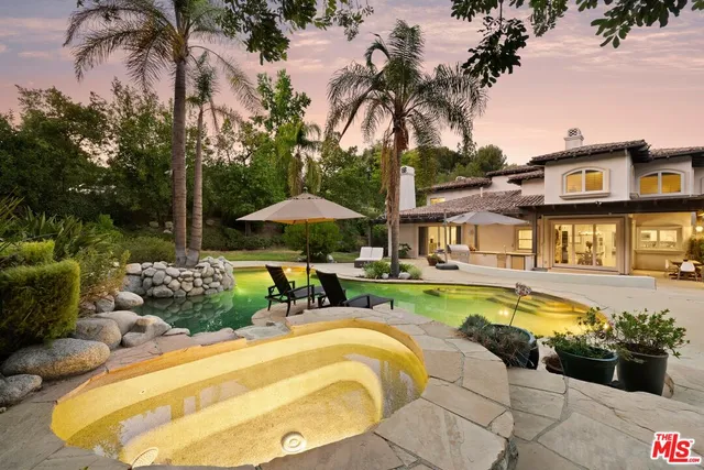 a swimming pool with outdoor seating and yard