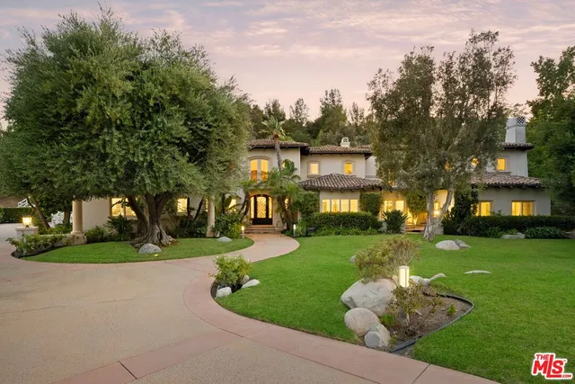 a front view of a house with a yard and trees