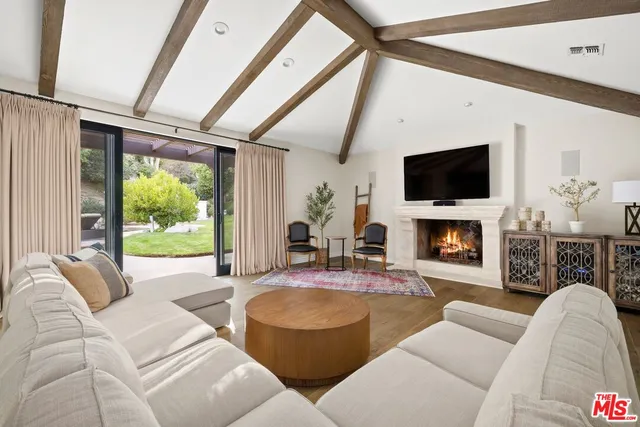 a living room with furniture a fireplace and a flat screen tv