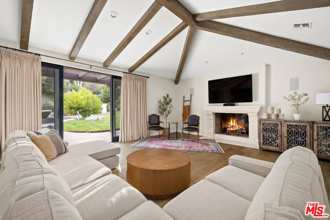 25217 Eldorado Meadow Road Hidden Hills, CA 91302 - Photo 5 of 28 a living room with furniture a fireplace and a flat screen tv
