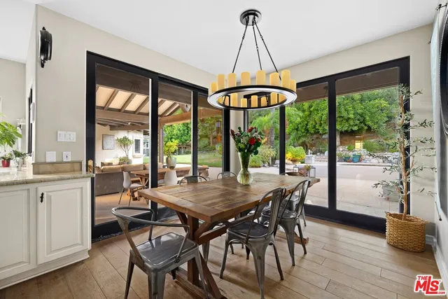 a dining room with furniture wooden floor a chandelier and a rug